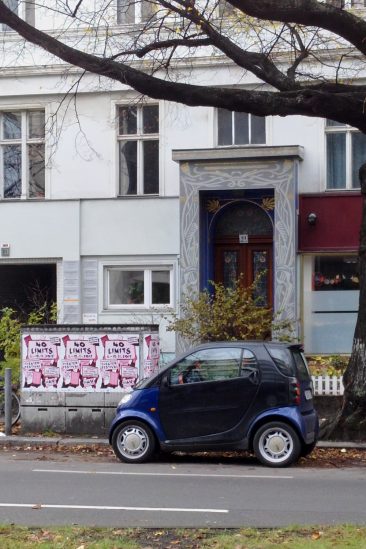 Ein blaues Smart-Car vor einem Lichtkasten voller NO-LIMITS-Plakate.